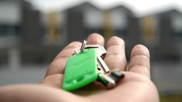 A hand holding a set of house keys